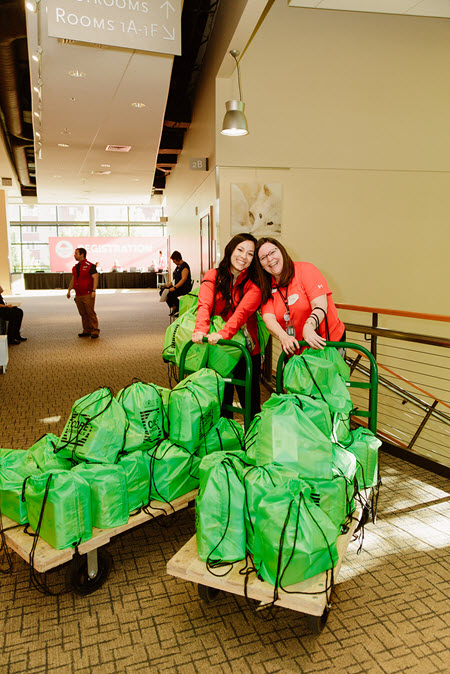 Two BECU employees with carts of STEM kits
